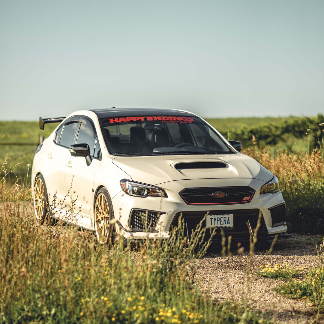 White Subaru WRX featuring a Happy Endings windshield banner decal