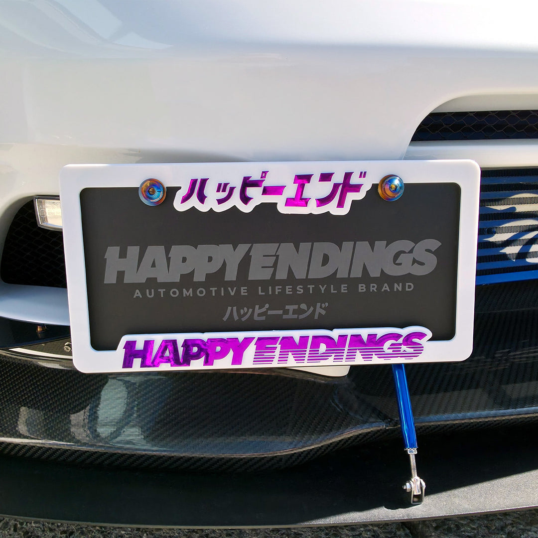 License Plate Frame - Purple Chrome Lettering (White Frame) - Happy Endings - Automotive & Lifestyle Brand