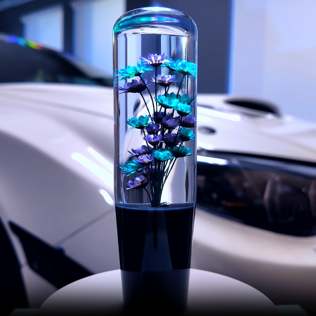Decorative vase with blue and purple flowers inside, placed on a car dashboard.