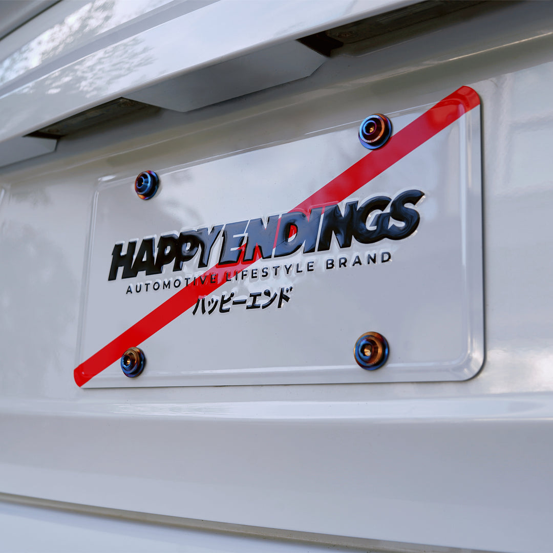 Close-up of a Happy Endings license plate with a red diagonal line and Japanese text.