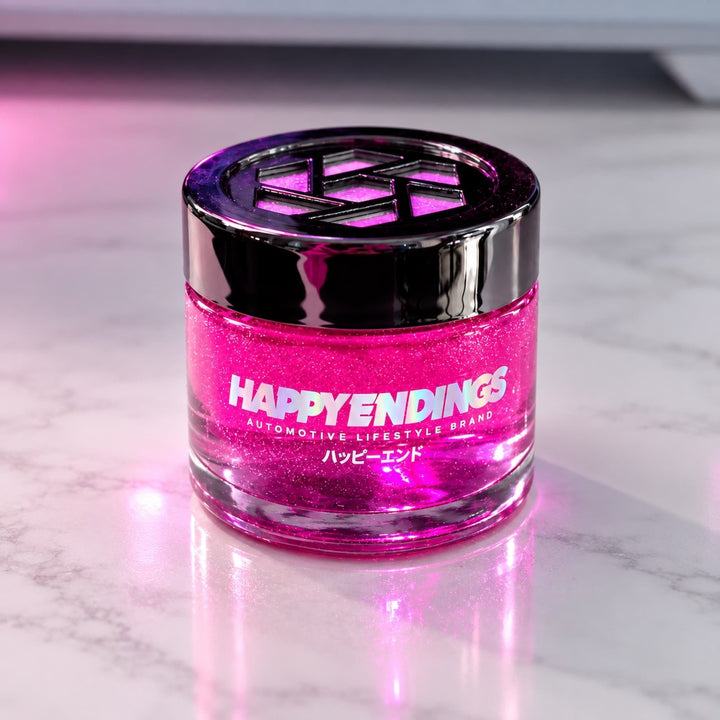 A jar of pink glitter gel labeled HAPPY ENDINGS on a white marble surface.