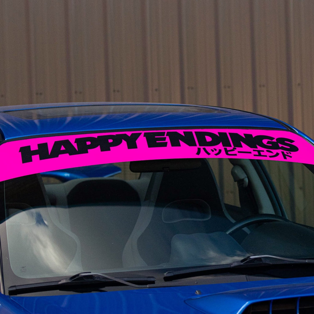 A blue car with a pink windshield banner reading HAPPY ENDINGS and Japanese text.