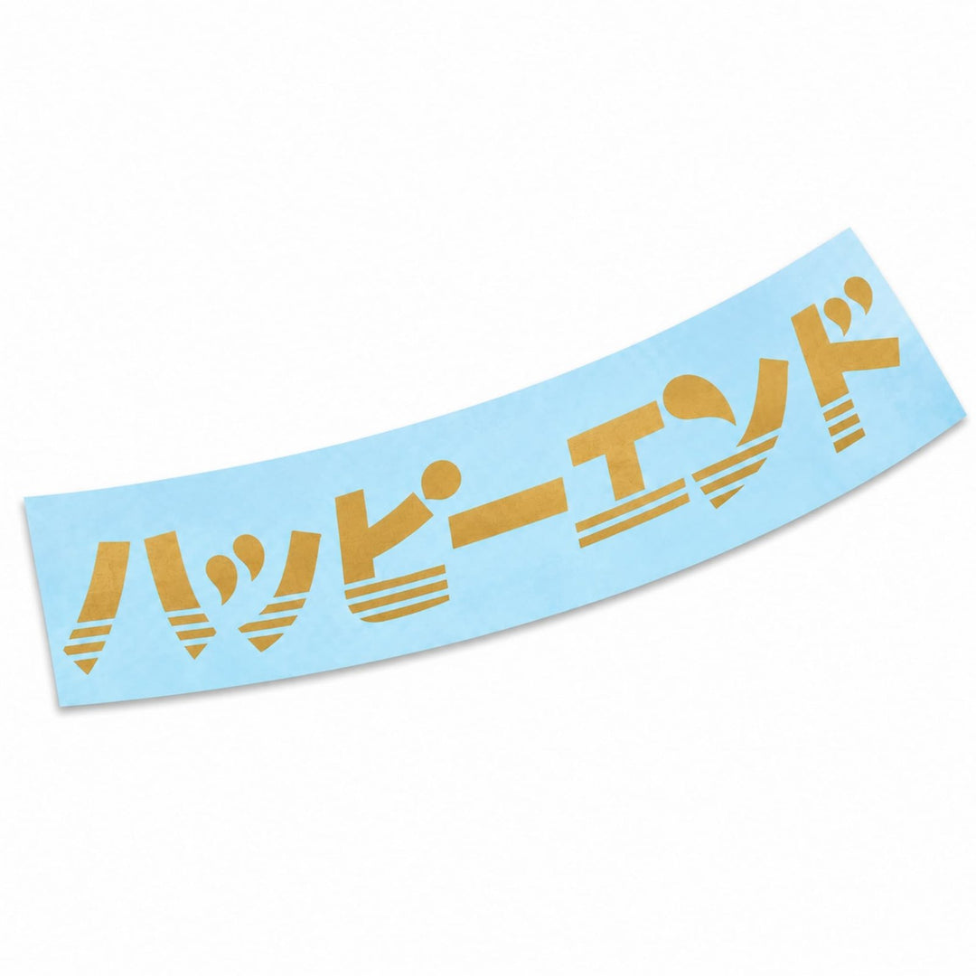 A light blue sticker with the gold Japanese text ハッピーエンド in a stylized font.