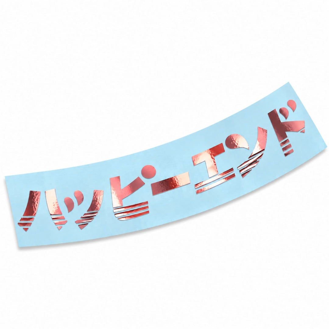 Metallic pink Japanese text reading Happy End on a light blue sticker.