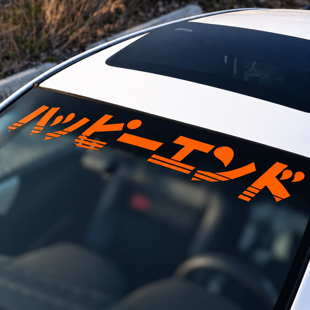 Orange Japanese text decal on a car windshield.