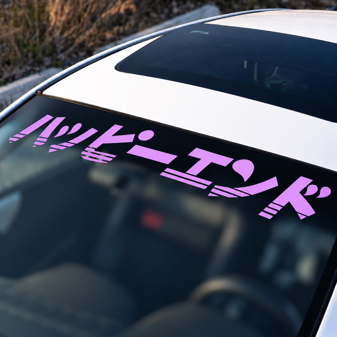 Pink Japanese text sticker on a car windshield.