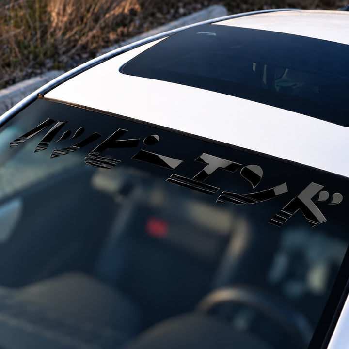 White car windshield with a black Japanese script decal.