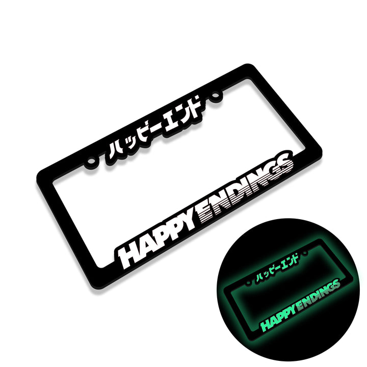 A license plate frame with HAPPY ENDINGS and Japanese text, glowing green in the dark.