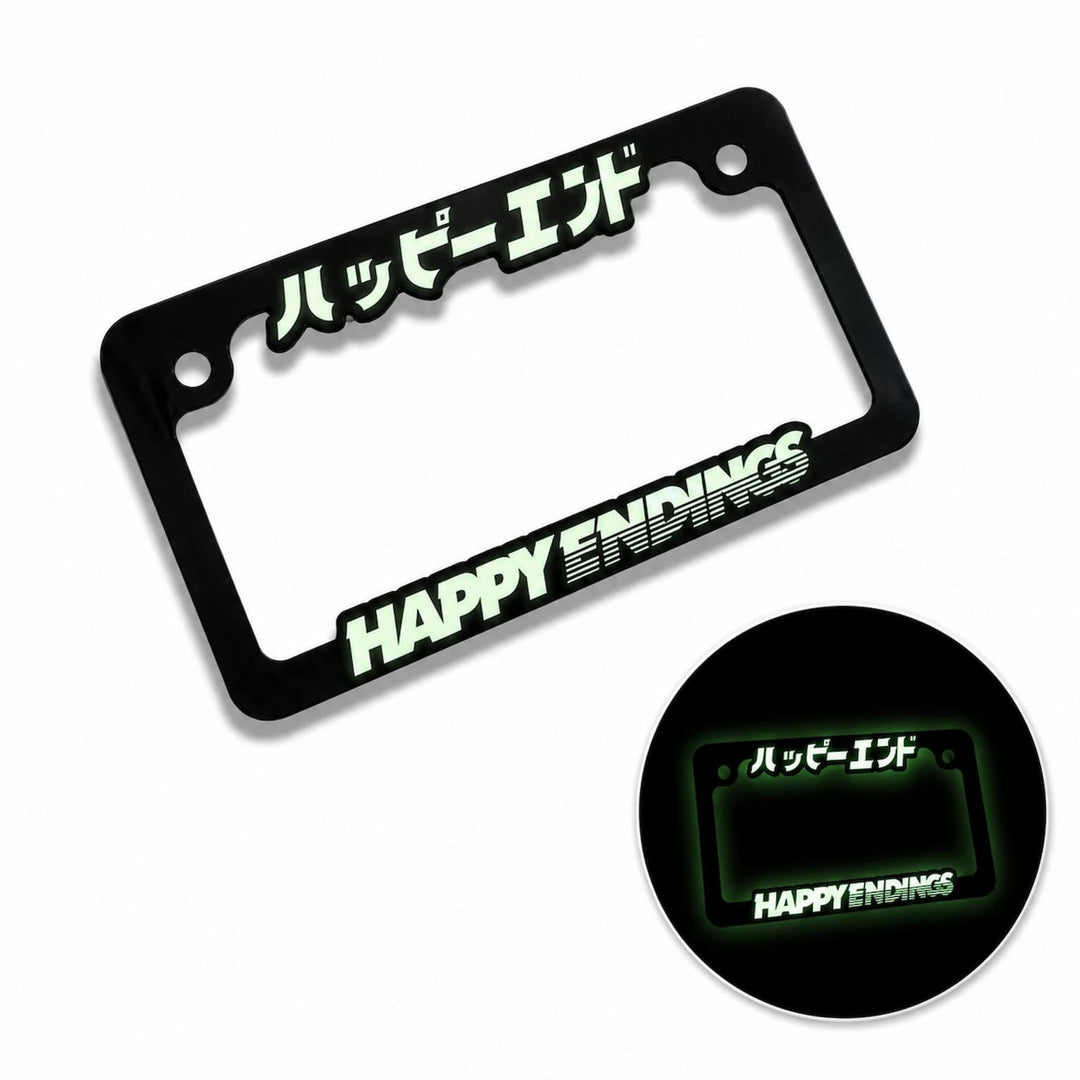 Black license plate frame with HAPPY ENDINGS and Japanese text, both glow in the dark.
