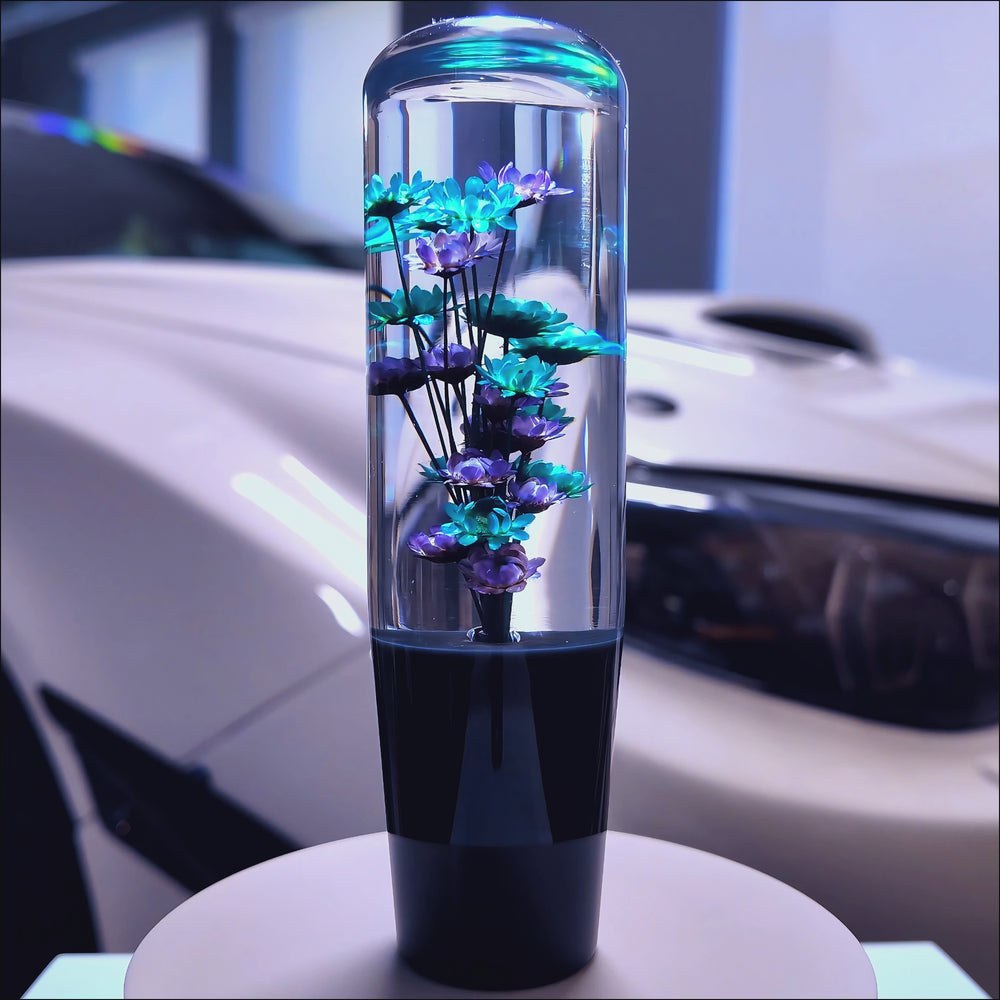 Clear resin shift knob with blue flowers suspended inside.