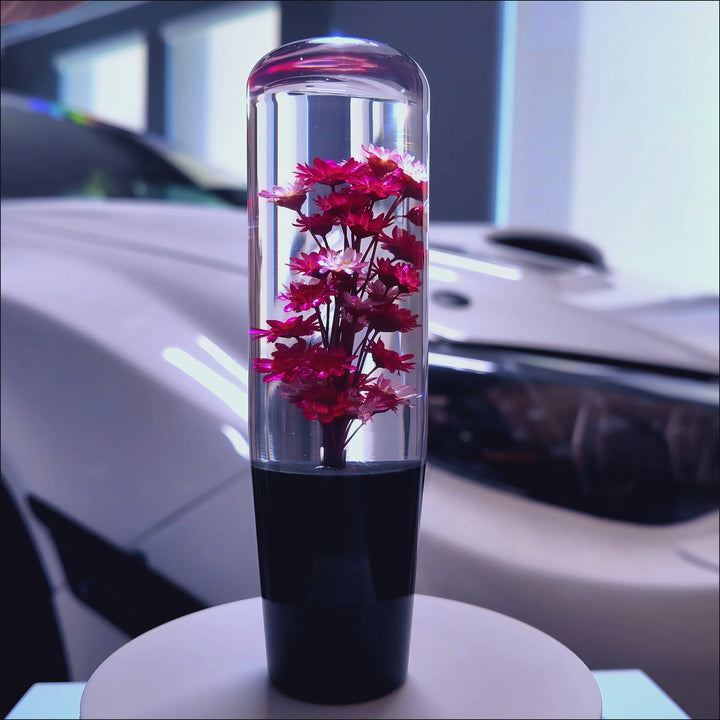 Clear resin shift knob with red flowers suspended inside.