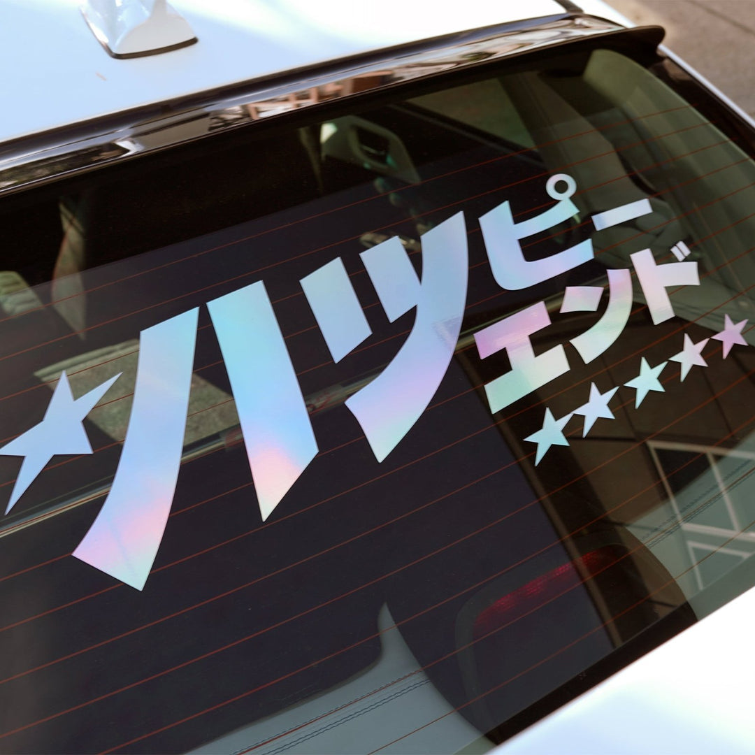 Sticker with Japanese text and stars on a car rear window.