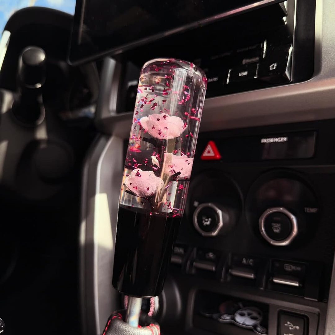 Decorative car air freshener with cherry blossoms in a car's console.