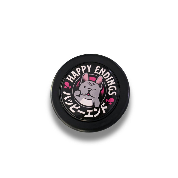 Round black object with a cartoon dog and 'Happy Endings' text on a white background