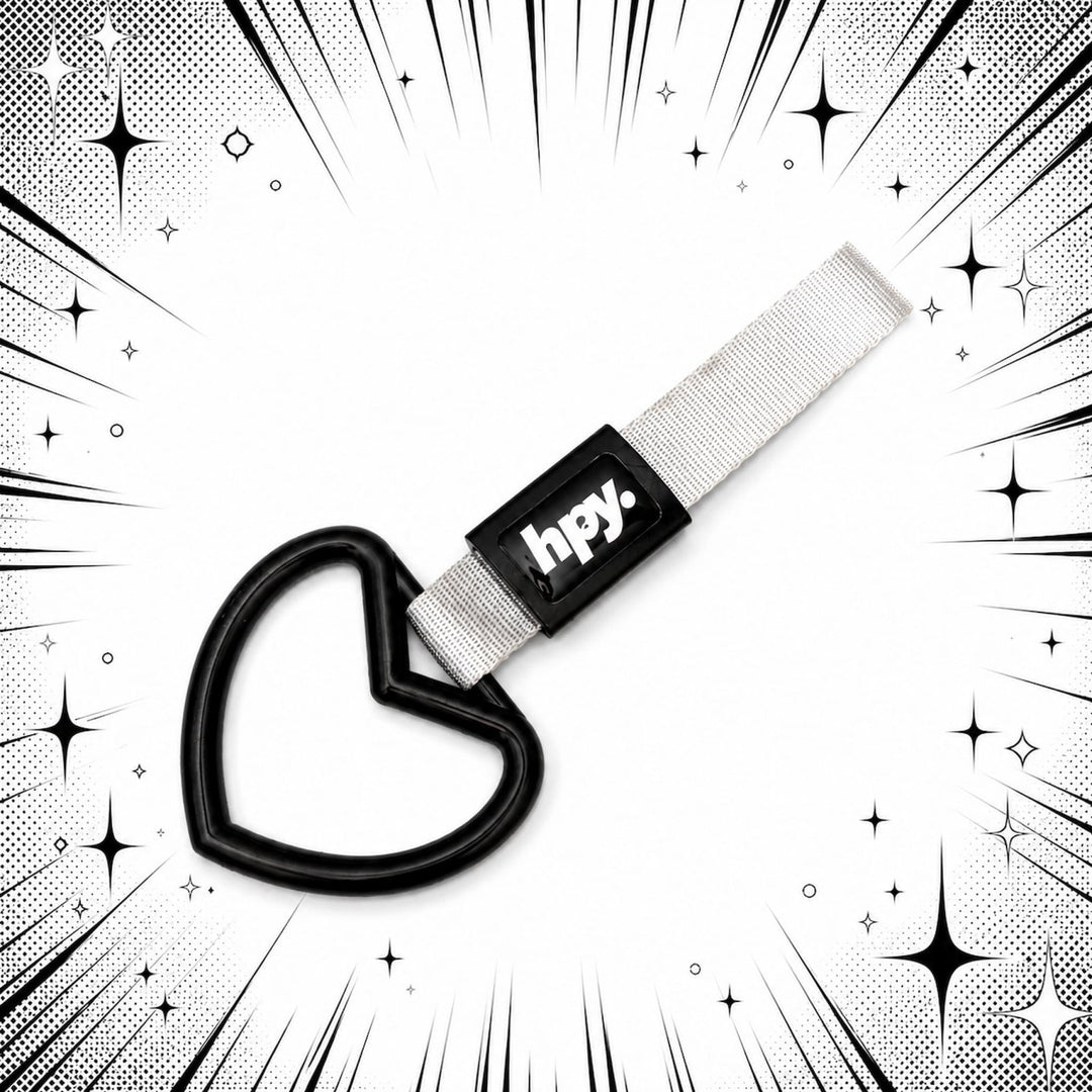 Heart-shaped keychain with hpy. tag on a white background with comic-style ef...