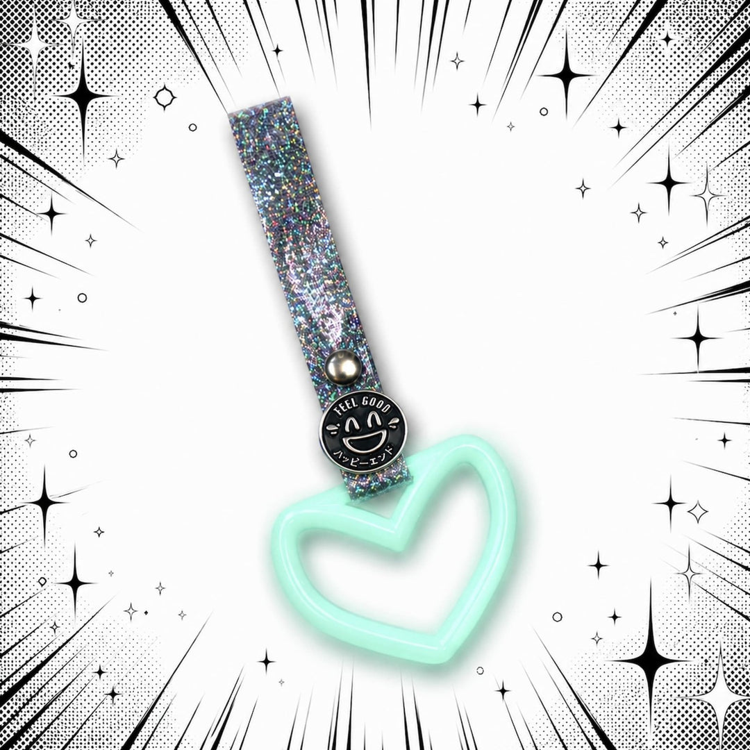 A mint green heart keychain with a sparkly strap on a comic-style starburst b...