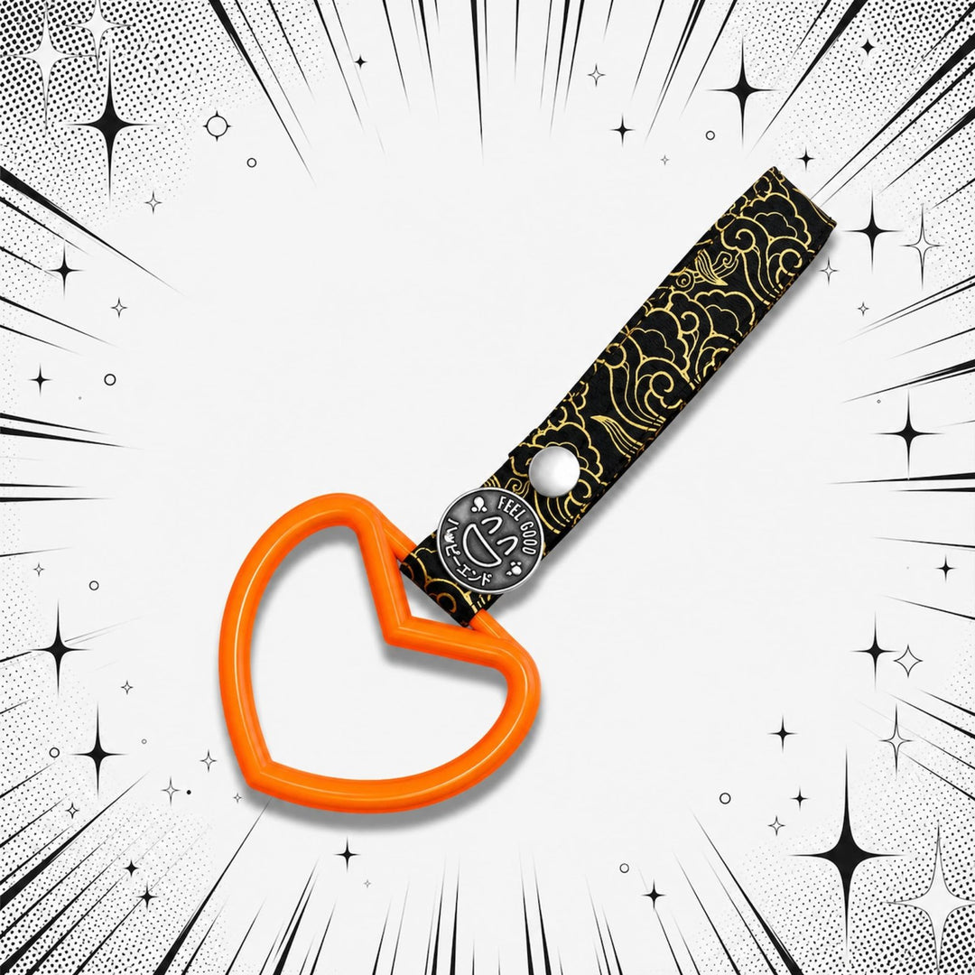 An orange heart-shaped keychain with a black and gold strap, set against a co...