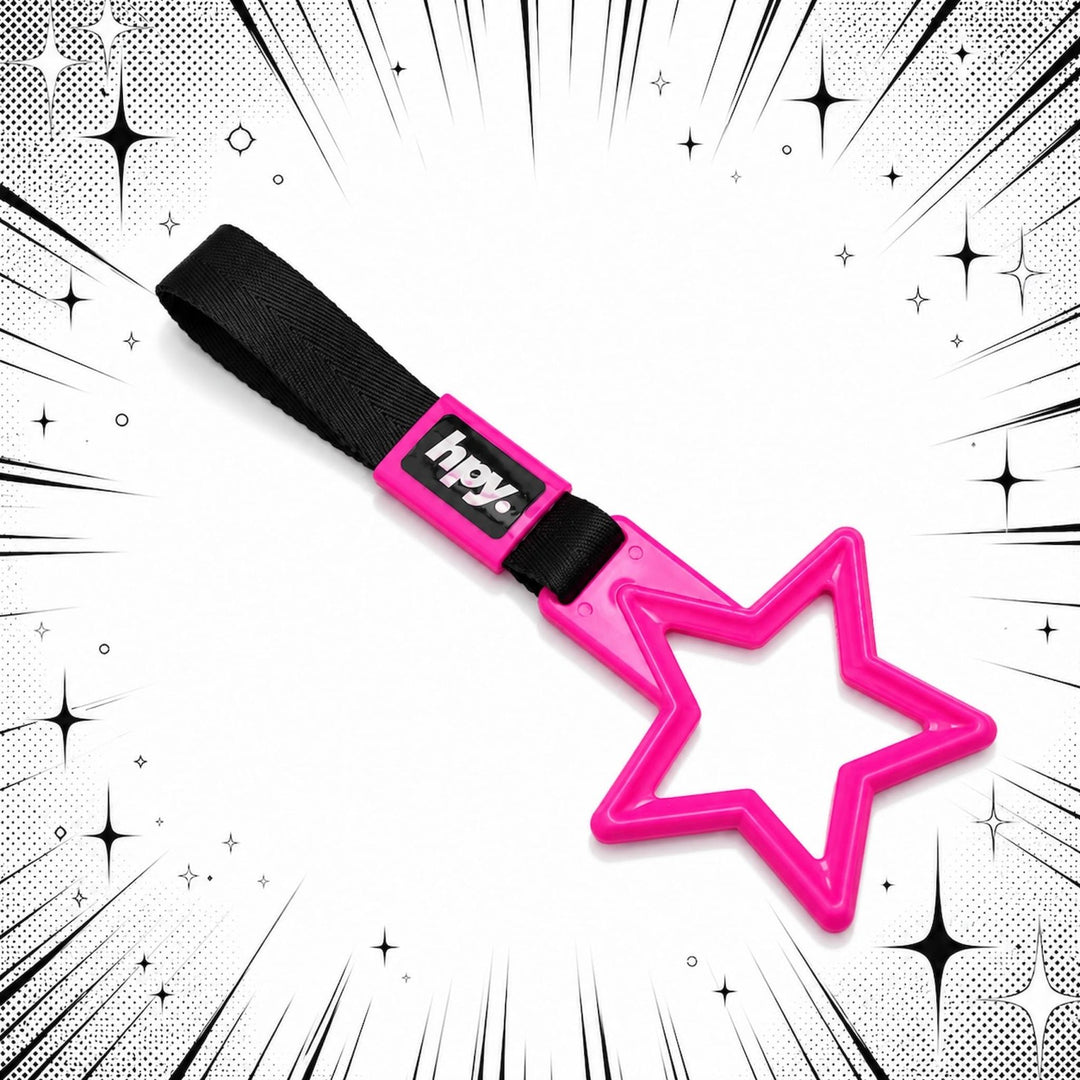 A pink star-shaped toy with a strap and hpy label, set against a comic-style ...