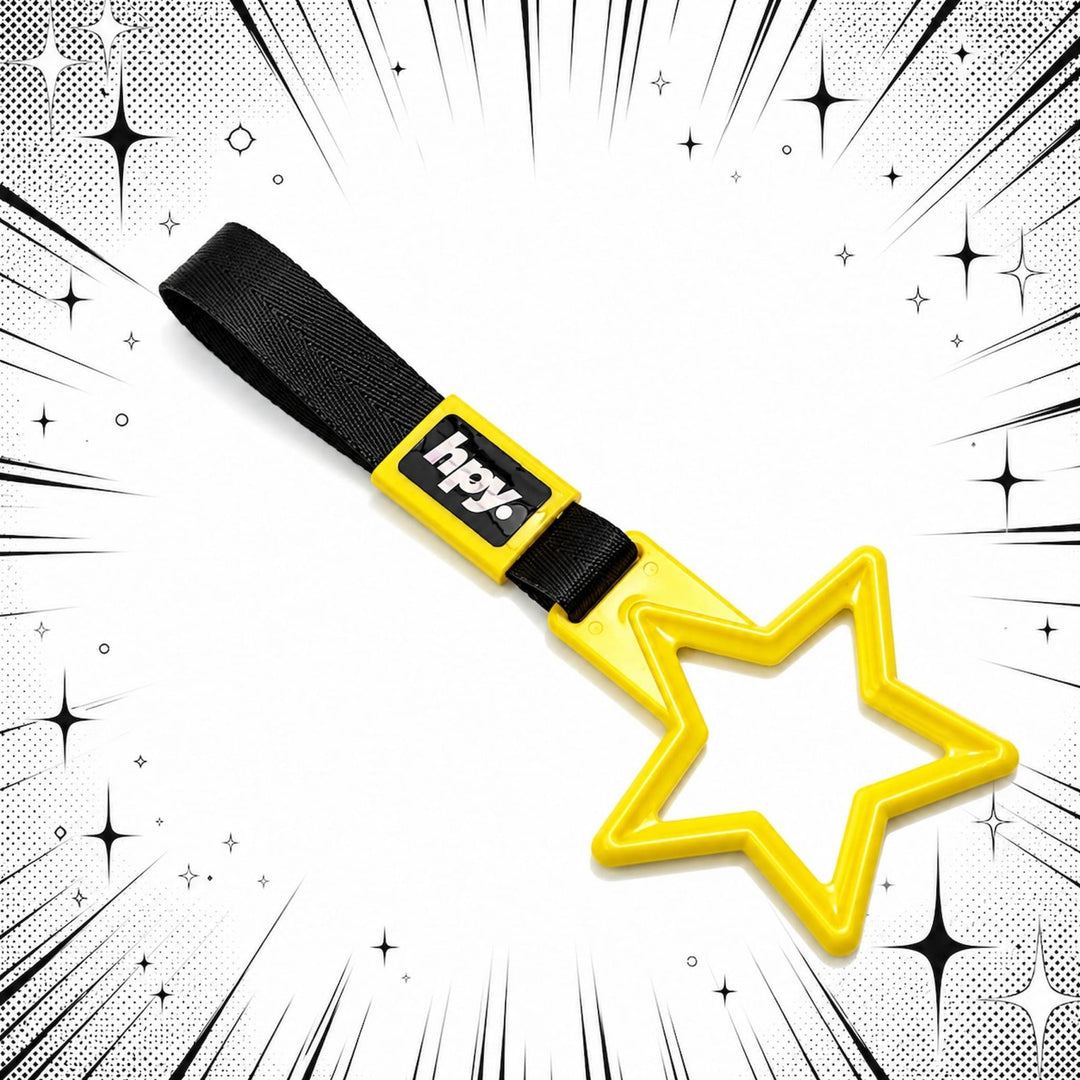 A yellow star-shaped keychain with a black strap labeled hpy on a comic-style...