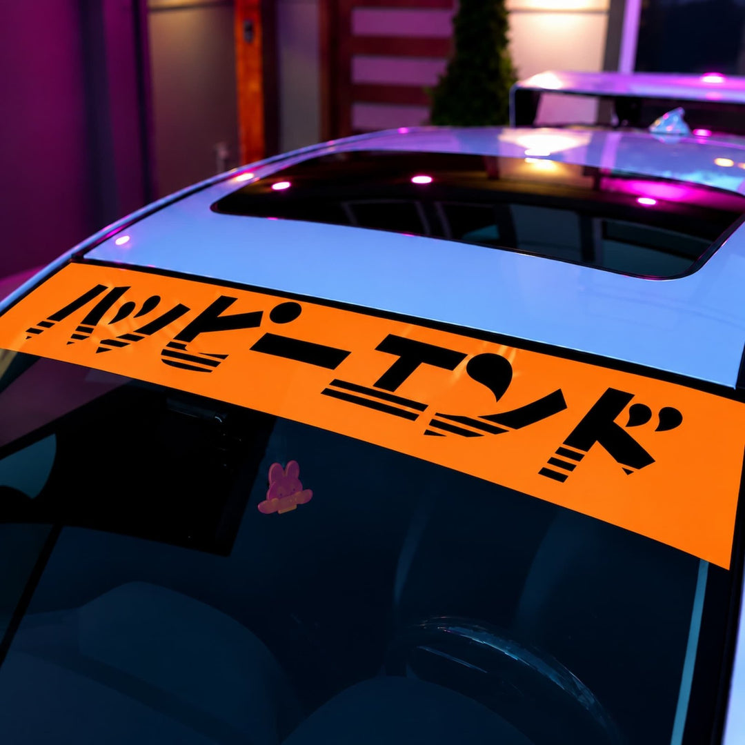 Orange windshield banner with Japanese text reading Happy End on a white car.