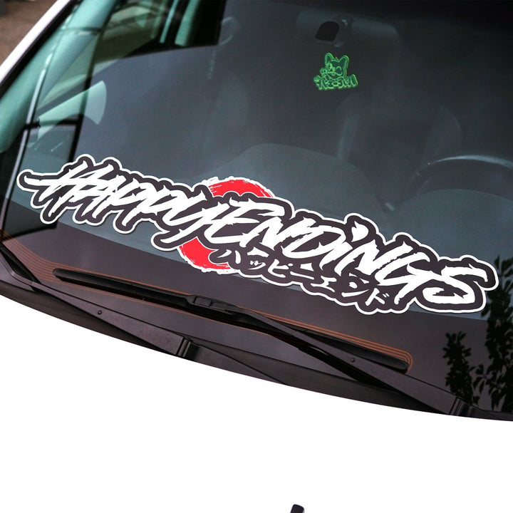 Car windshield decal reading HAPPY ENDINGS in stylized script over a red circle.