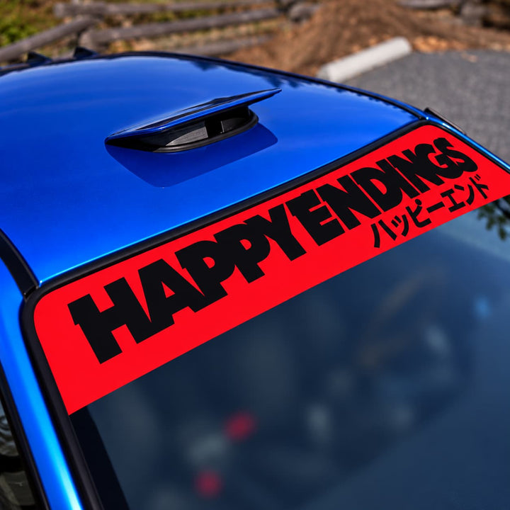 Red car windshield banner reads HAPPY ENDINGS with Japanese text on a blue car.