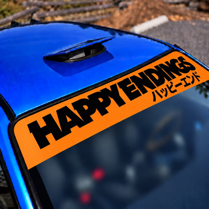 Blue car with HAPPY ENDINGS and Japanese text decal on the windshield.