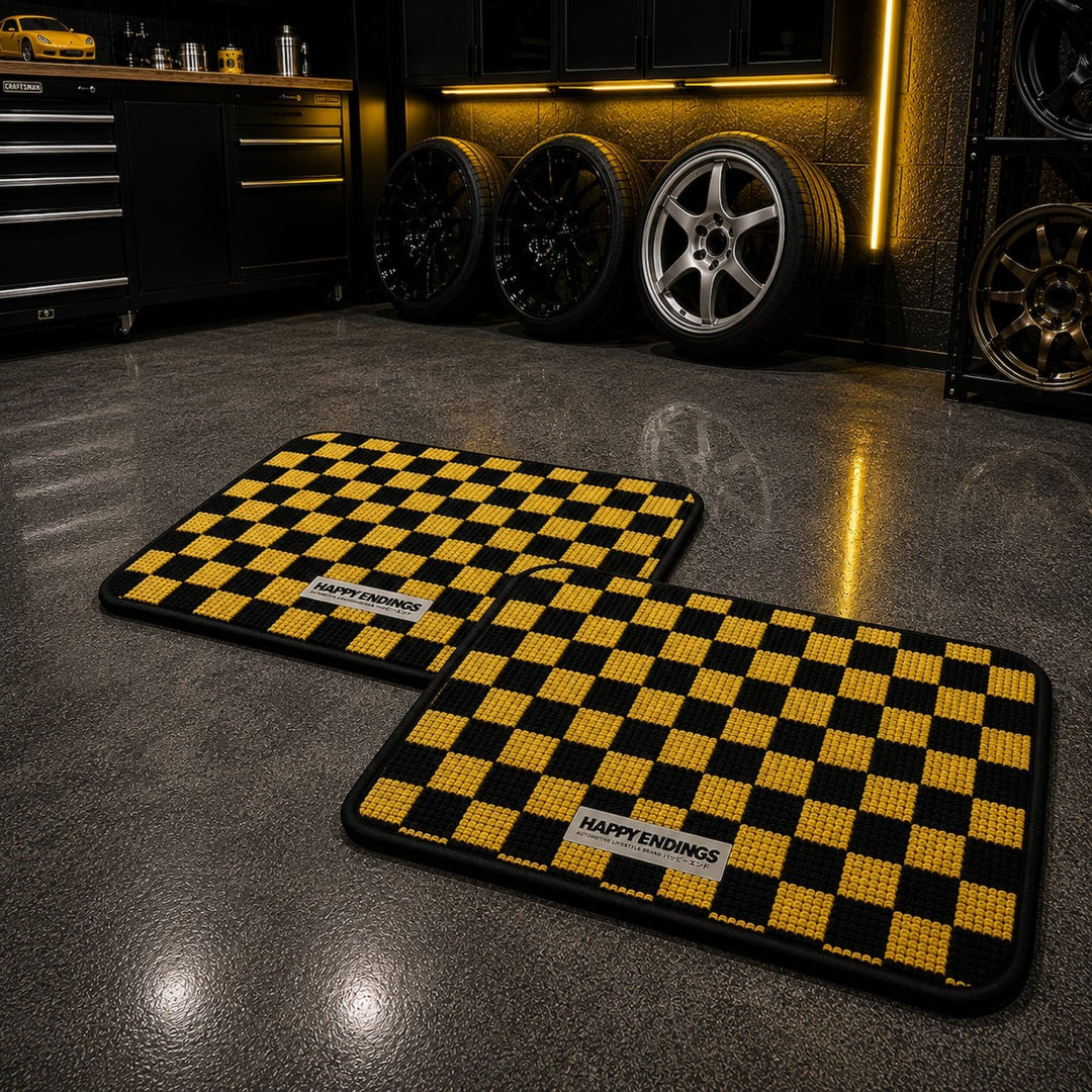 Two yellow and black checkered floor mats labeled HAPPY ENDINGS in a sleek ga...